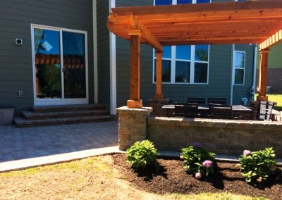 Paver patio with stone wall and pergola - AFTER